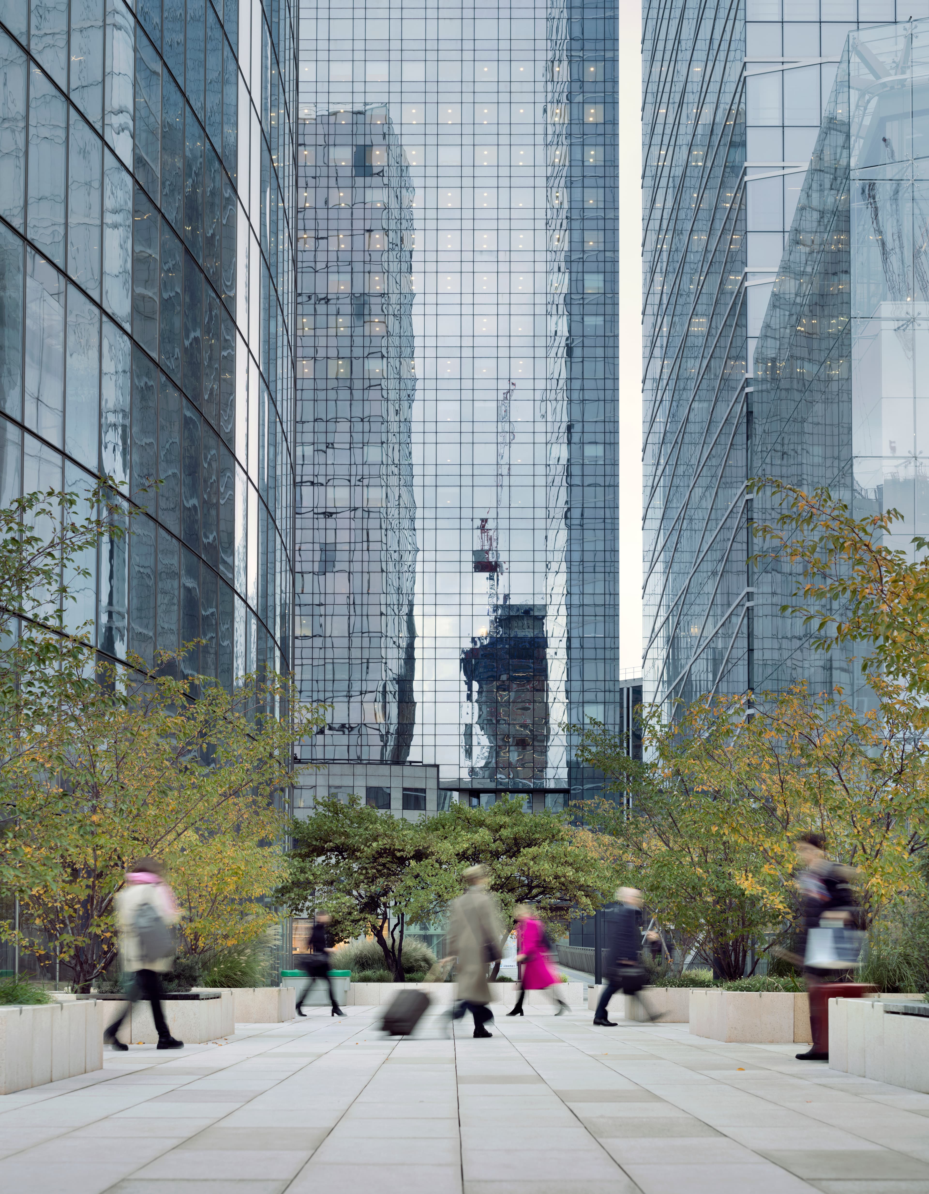 Motion blurred office workers and business people, arriving for work at La Defense business district in Paris, France.